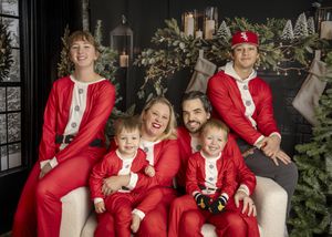 The Aparicios in festive Christmas jammies on a white couch.